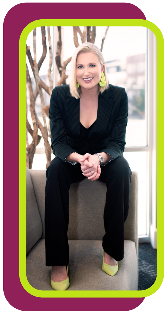 Katherine M. Sauer wearing a black suit with lime green accessories, seated on a couch arm